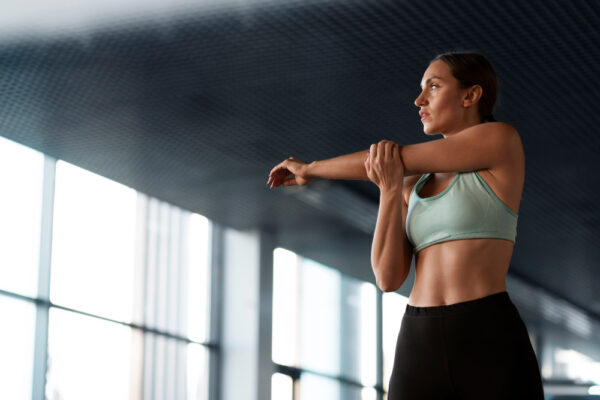 Woman stretching her arms at the gym