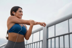 Woman stretching outdoors before exercise, representing healthy lifestyle habits, physical activity, and sustainable wellness practices that complement clinical GLP-1 treatment programs.